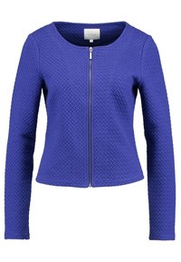 Lila texturerad jacka med rund halsringning, långa ärmar och dragkedja framtill, tillverkad av ett vävt tyg.