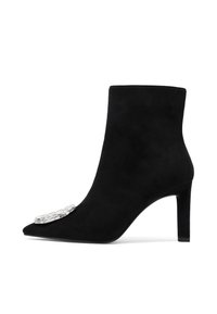 Stivale alla caviglia in suede nero con punta a punta, tacco di media altezza e decorazione in argento a forma rettangolare con gioielli sulla punta.