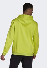 Neon-gelbes Hoodie aus weichem Baumwollmix, mit Kapuze mit Kordelzug sowie gerippten Bündchen und Saum. Glatte Textur, lässige Passform.
