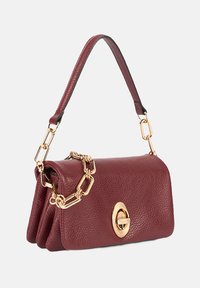 Burgunderfarbene Lederhandtasche mit strukturierter Oberfläche, ausgestattet mit einem massiven goldenen Kettenriemen und einem runden Verschluss. Kompakt und rechteckig im Design.