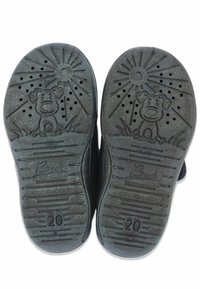 Schwarze Gummisohlen mit einem verspielten Hundegrafik, Sonnenstrahlenmuster und strukturiertem Profil für guten Halt. Mit der Prägung "20" als Größenlabel.