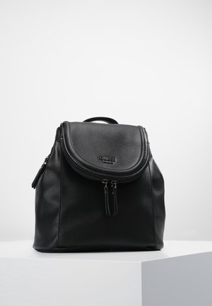 Sac à dos Guess en cuir noir avec rabat arrondi, doubles tirettes de fermeture éclair et poignée supérieure, présenté sur un socle blanc sur un fond uni.