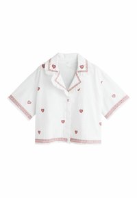 Fehér rövid ujjú gombos ing fodros gallérral, vörös hímzett szívekkel szétszórva, valamint vörös mintás szegéllyel a galléron, ujjakon és szegélyen.