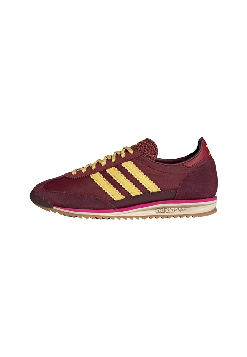 Bordeaux atletisk sko med gul tre-stribe design og beige sål. Har en tekstureret overdel og en lyserød mellemsål accent.