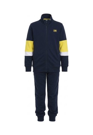 Survêtement bleu marine avec une veste zippée, des bandes jaunes et blanches sur les manches et un pantalon assorti à bas resserrés.