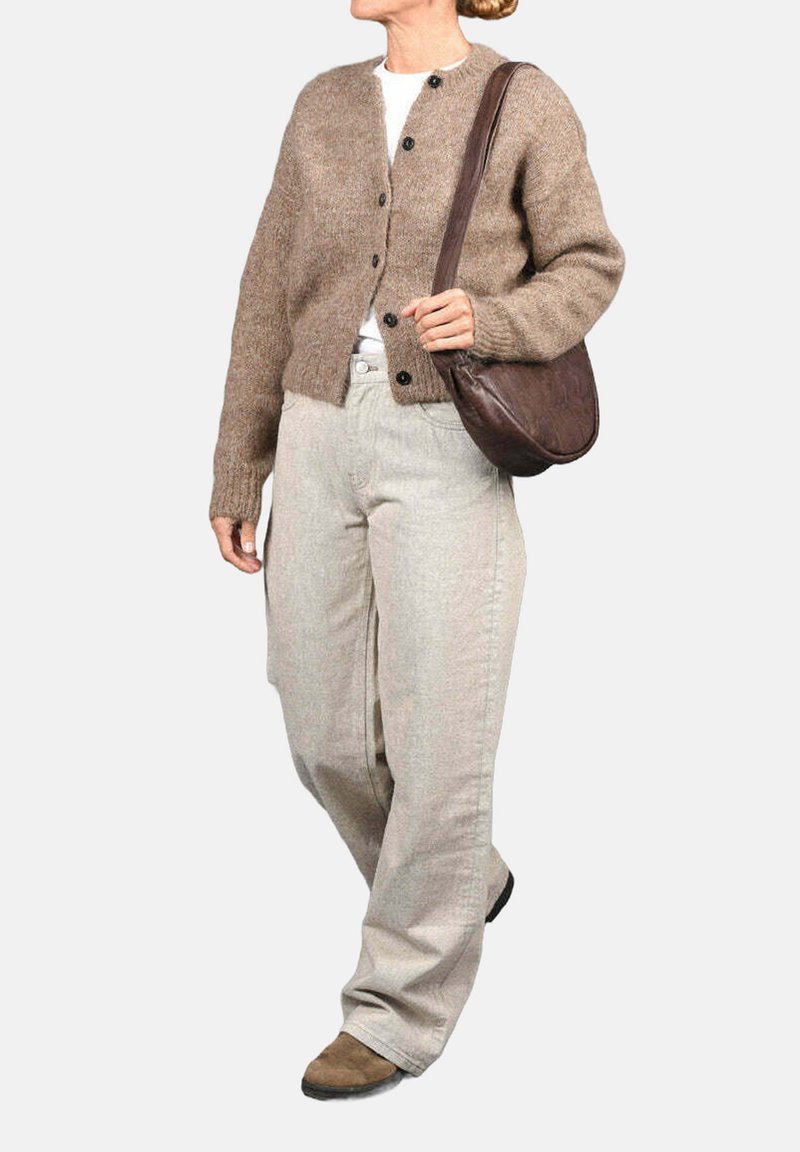 Cárdigan marrón de punto con cierre de botones, combinado con pantalones de pierna ancha en gris claro y un bolso de hombro de cuero marrón.