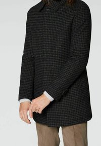 Abrigo a rayas en negro y gris con cuello tipo solapa, tejido texturizado y cierre de botones. Presenta puños en gris acanalado.
