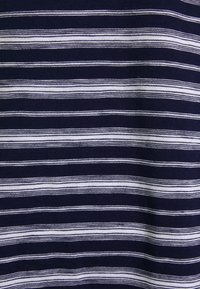 Tissu bleu marine avec des rayures horizontales blanches. La texture semble lisse et tricotée, avec des rayures de largeurs variées.