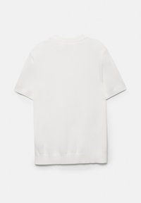 Chemise blanche unie à manches courtes avec un col rond côtelé et un ourlet, vue de dos sur fond blanc.