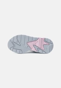 Weiße und graue Sneaker-Sohle mit pinken Akzenten. Verfügt über strukturierte Muster für den Grip, einschließlich erhabener Abschnitte und kreisförmiger Vertiefungen.