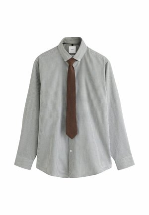Man with light beard wearing a small black and white checked button-down shirt with white buttons and a buttoned collar.