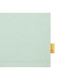 Camiseta de algodón verde menta con una textura suave, dobladillo corto a los lados y una pequeña etiqueta amarilla de la marca en la costura.