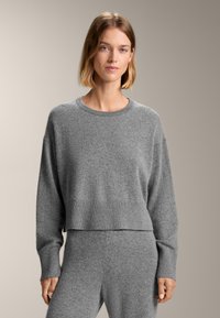 Grauer gestrickter Pullover mit einem verkürzten Design, gerippten B�ündchen und einem weiten Rundhalsausschnitt. Weiche Textur mit lockerer Passform.