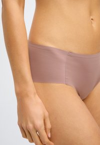 Svetlomauve hipsterské spodné prádlo vyrobené z hladkej, elastickej látky s bezšvovým dizajnom, s nízkym pásom a bez viditeľného šitia.