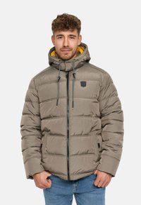 Polstret zip-jakke i dempet grå med en kontrastfarget gul hetteforing. Har elastiske snorene, sidelommer og et logo-patch.