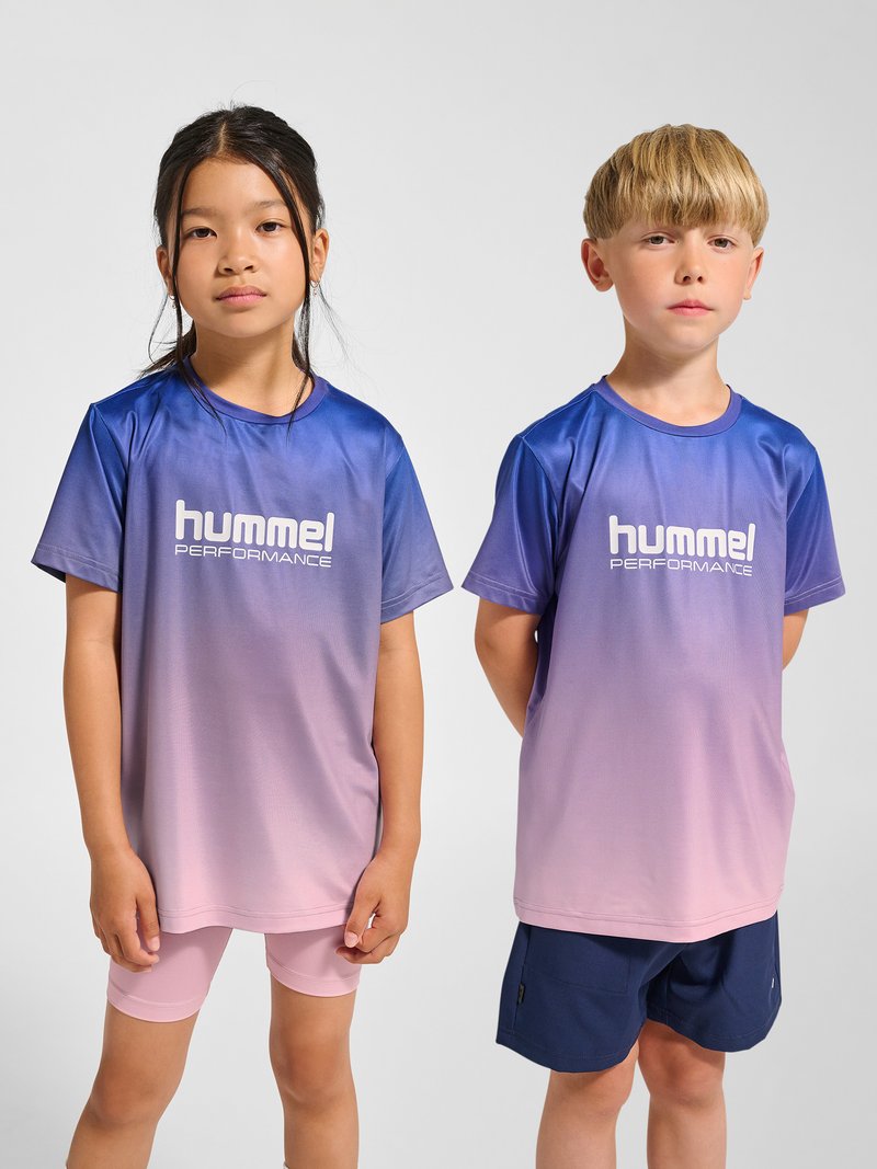 To børn står side om side iført sports T-shirts fra "hummel performance" med blå til pink gradient, det ene i pink shorts, det andet i marineblå shorts.