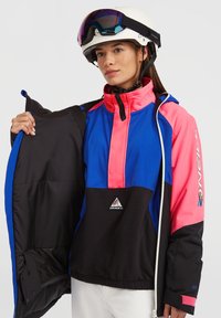 Kleurrijke ski-jas met blauw, roze en zwarte panelen, een hoge kraag, ritszakken en een binnenvoering. Logo aan de voorkant.