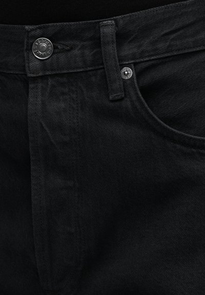 Čierne rifľové nohavice so zapínaním na gombíky, prednými vreckami a rovný strihom. Textúra je hladká s jemnými detailmi materiálu.