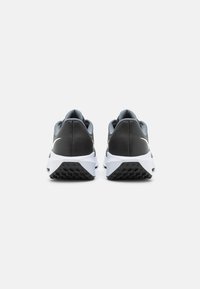 Pantofi sport pentru bărbați cu un design superior negru și gri, talpă intermediară albă, talpă texturată și detalii distincte ale logo-ului. Dispun de guler și limbă căptușite.