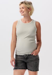 Ljusgrått ribbat linne med rund halsringning, i kombination med mörka denimshorts. Tyget ser mjukt ut och har en figursydd design.