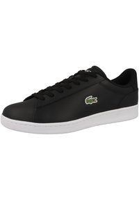 Svart lær sneakers med hvit gummisåle, med rund tå, snøring og et grønt brodert krokodillologo på siden.