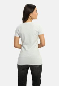 Lys grå kortærmet t-shirt med en tætsiddende pasform og rund hals, lavet af blødt stof. Bagsiden er glat med en let stræk.