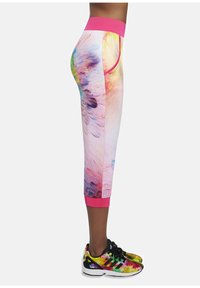 Kolorowe legginsy do kostek z różowym pasem, z wielokolorowym abstrakcyjnym wzorem. Materiał wydaje się elastyczny i dopasowany.