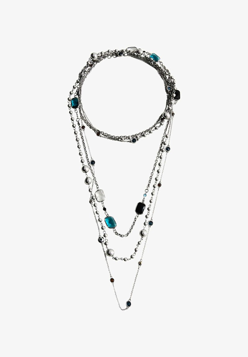 Collier en argent multi-couches avec des chaînes de tailles variées et des perles rondes et rectangulaires bleues, noires, blanches et argentées.