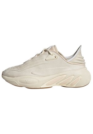 Kremowy sneaker Adidas z teksturowaną górą wykonaną z tkaniny, grubą rzeźbioną podeszwą i subtelnym brandingu na podeszwie oraz oczku sznurowadła.