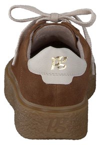 Scarpa in suede marrone con un accento in pelle bianca nel tallone. Presenta una suola in gomma leggera marrone chiaro texturizzata e lacci beige.