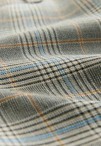 Woven fabric featuring a light gray base with black and blue plaid patterns. Notable texture with visible thread detail and soft drape.