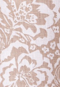 Motif floral beige et blanc avec de grandes fleurs et feuilles sur un fond de tissu tissé texturé.