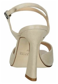 Sandalo beige in suede con tacco alto, cinturino alla caviglia e fibbia color argento. Presenta un tacco curvato e una soletta liscia e testurizzata.