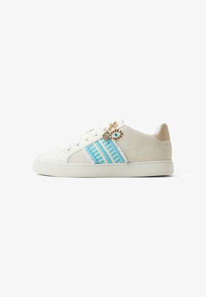 Witte sneaker met blauw gestreepte baan, veterontwerp, beige hielstuk en goudkleurige oog- en handhanger bevestigd bij de veters.