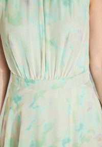 Leichtes, fließendes Kleid in pastellgrünen, blauen und lavendelfarbenen Nuancen mit einem aquarellähnlichen Muster; verfügt über eine geraffte Taille für eine schöne Form.