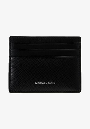 Svart skinn kortholder med fire spor. Teksturert finish og preget logo "MICHAEL KORS" i sølv nederst. Kompakt rektangulær form.