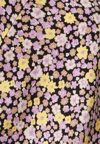 Tecido estampado com pequenas flores em tons de rosa e amarelo sobre um fundo preto, com um entrelaçado texturizado que confere profundidade.