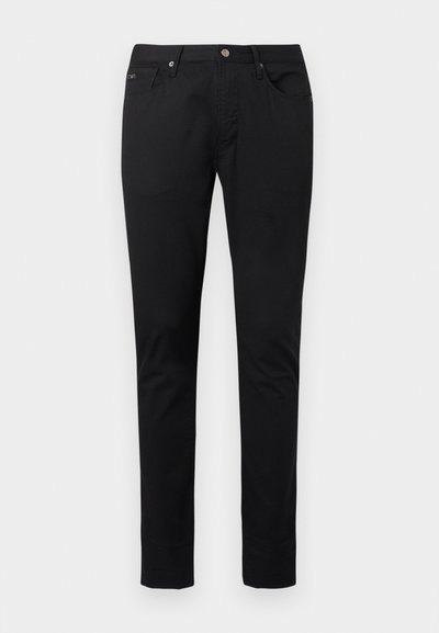 Μαύρο στενό παντελόνι ανδρικό με κουμπί μπροστά, φερμουάρ, θηλιές για ζώνη και σχέδιο με πέντε τσέπες σε απλό ανοιχτό φόντο.