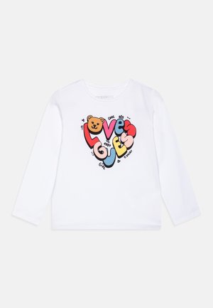 Maglietta bianca a maniche lunghe con design colorato a forma di cuore "Love Guess", che presenta un volto di orso e testo giocoso in rosso, blu, rosa e giallo.