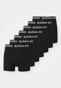 Sieben schwarze Boxershorts mit weißem "BJÖRN BORG"-Text auf dem Bund, in einer versetzten Anordnung auf einem weißen Hintergrund gestapelt.