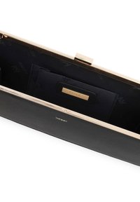 Juodas odinis rankinės vidus su auksinės spalvos rėmu. Yra mažesnė juoda kišenėlė ir logotipo akcentai ant iškloto audinio. Paprastas, struktūruotas dizainas.