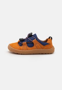 Chaussure en daim orange et en tissu bleu avec une semelle en caoutchouc texturé, un système de laçage élastique et des découpes latérales pour la ventilation.