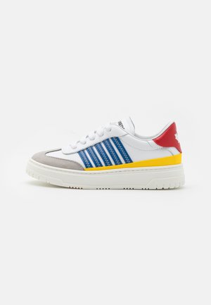 Sneaker bianco con strisce orizzontali blu, punta grigia, suola intermedia gialla e tallone rosso con dettaglio della foglia d'acero.