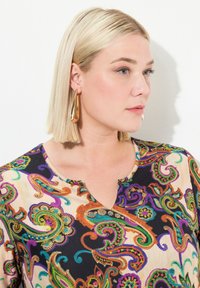 Mehrfarbige Paisley-Bluse mit schwarzem Hintergrund, V-Ausschnitt und aufwändiger Stickerei in lila, grün, orange und blauen Tönen.
