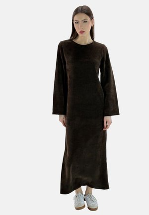 Brown, long-sleeve maxi dress made of soft fabric with a relaxed fit, paired with white sneakers featuring a light brown sole.