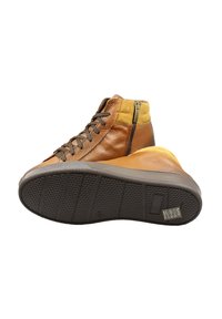 Sneakers alte in pelle marrone con un accento dorato, superficie strutturata, lacci marroni e cerniera laterale. Suola in gomma con scanalature.