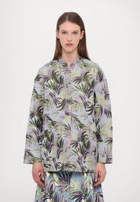 Blumenmuster-Jacke in Hellblau mit langen Ärmeln, Stehkragen und abstrakten grünen und lila Blattmustern.