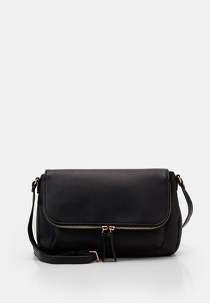 Sac bandoulière en cuir noir avec rabat avant, fermeture éclair dorée et bandoulière réglable sur fond blanc.
