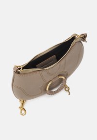 Bolso de mano de cuero beige con forma estructurada, herrajes en tono dorado, detalle de costura exterior y asa trenzada. Apertura superior con cremallera.