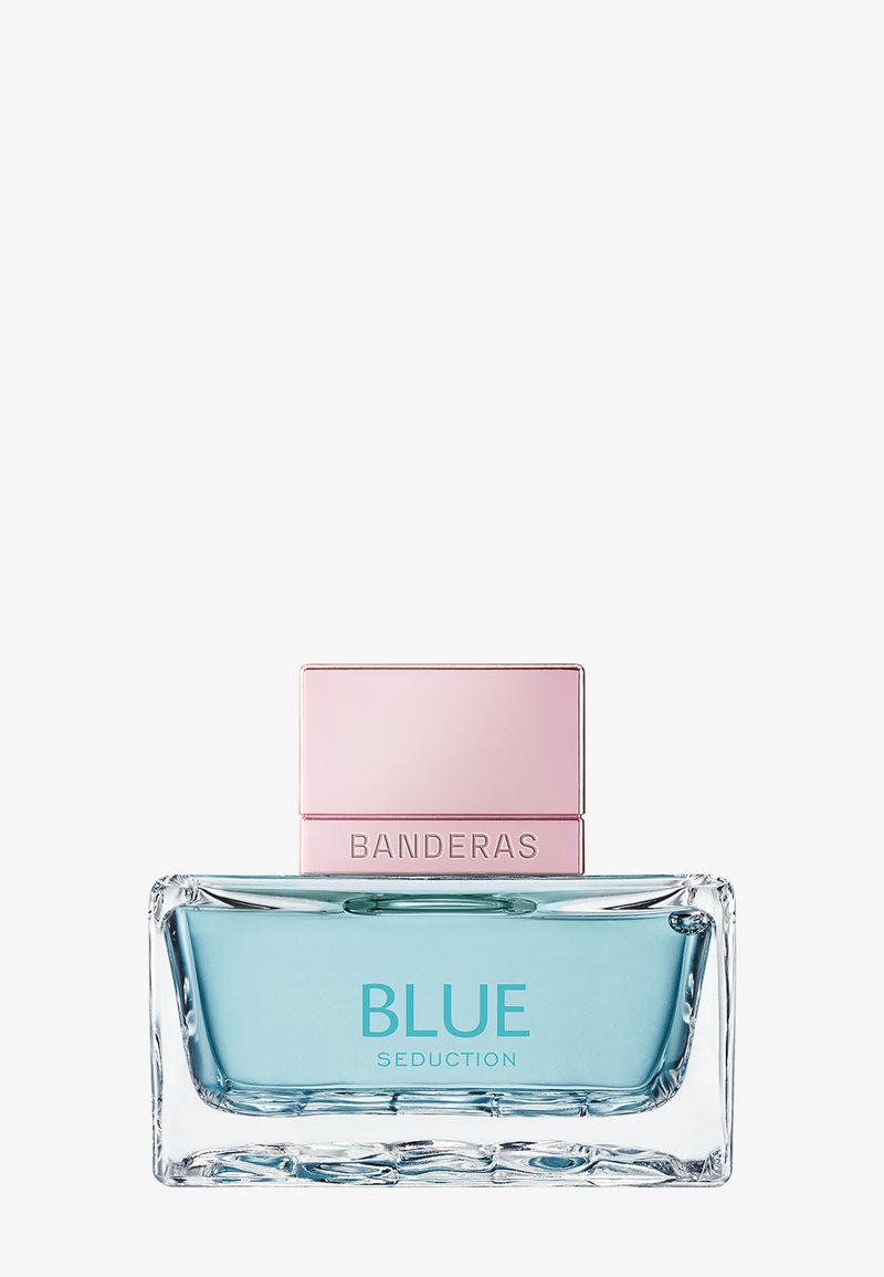 Rektangulær glas parfume flaske med lyseblå væske og pink låg, mærket "BLUE SEDUCTION BANDERAS."